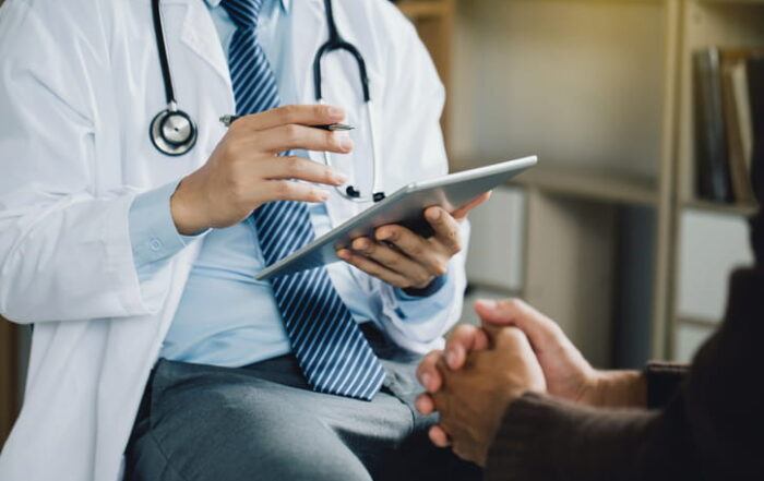 An Unidentifiable Doctor Performing Health Screening Tests On Their Patient.