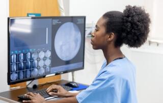 female nurse looking at scan results on monitor