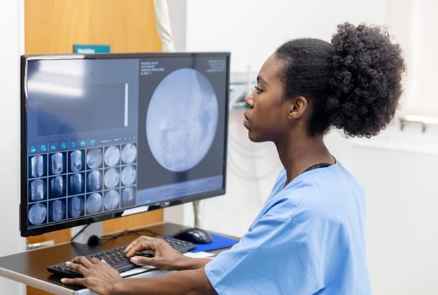 female nurse looking at scan results on monitor