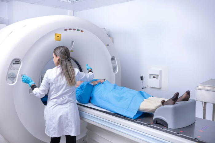 A Doctor Assisting A Patient As They Get A Ct Scan To Rule Out Lung Cancer.