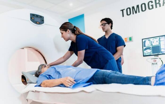 A Male And Female Nurse Preparing A Patient For Their Ct Scan