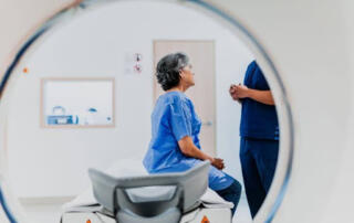 Woman Sitting On Surface Talking To Doctor In Preparation For Her Ct Scan