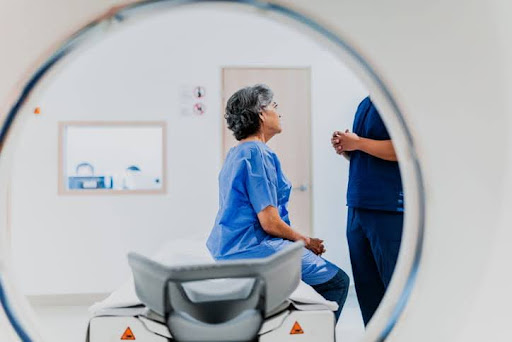 Woman Sitting On Surface Talking To Doctor In Preparation For Her Ct Scan