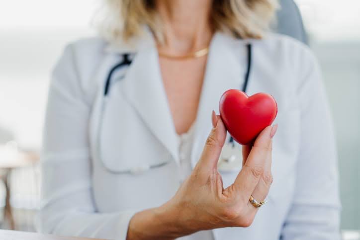 Female Doctor In White Coat Holding A Red Heart 